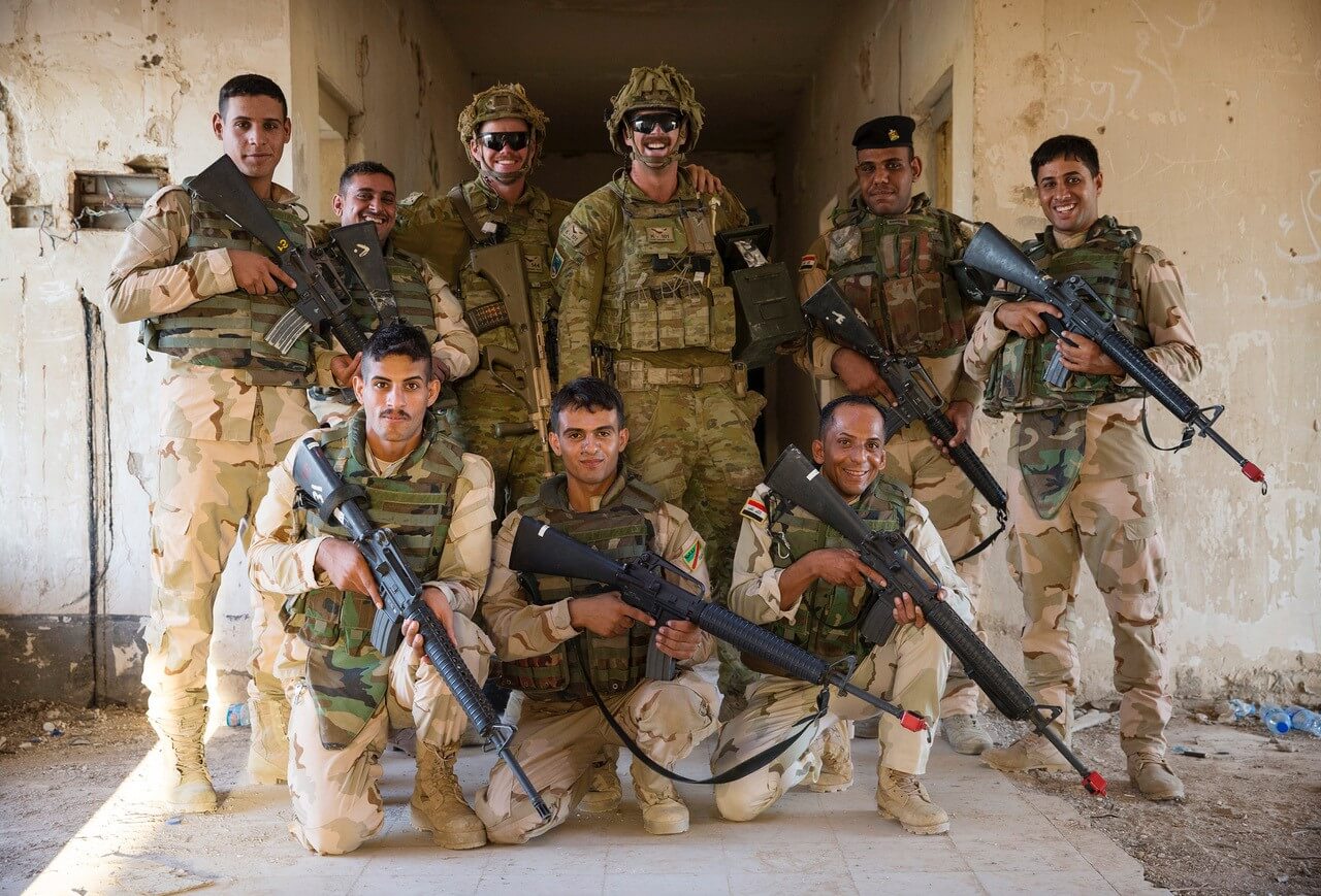 CPL Jack Dugan (centre) poses with his Iraqi Army trainees at the Urban Training Area on Camp Taji, Iraq.